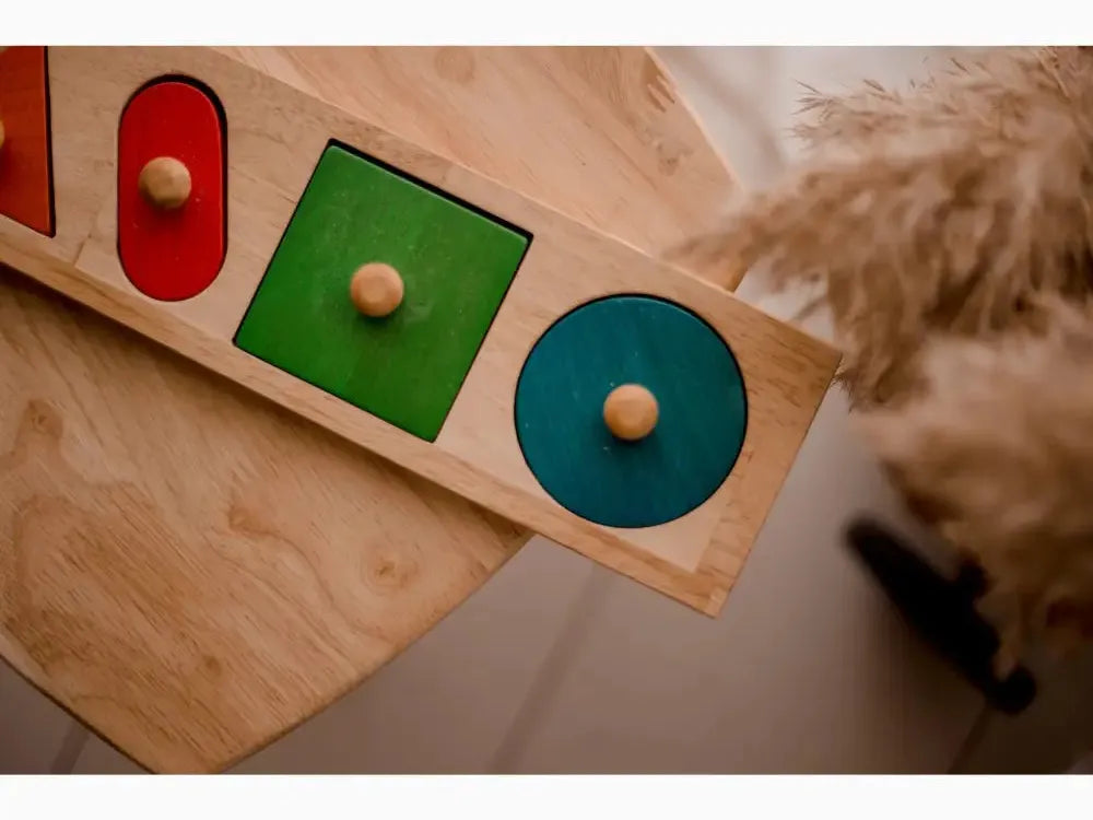 Wooden shape sorter toy with colorful geometric cutouts and round pegs.