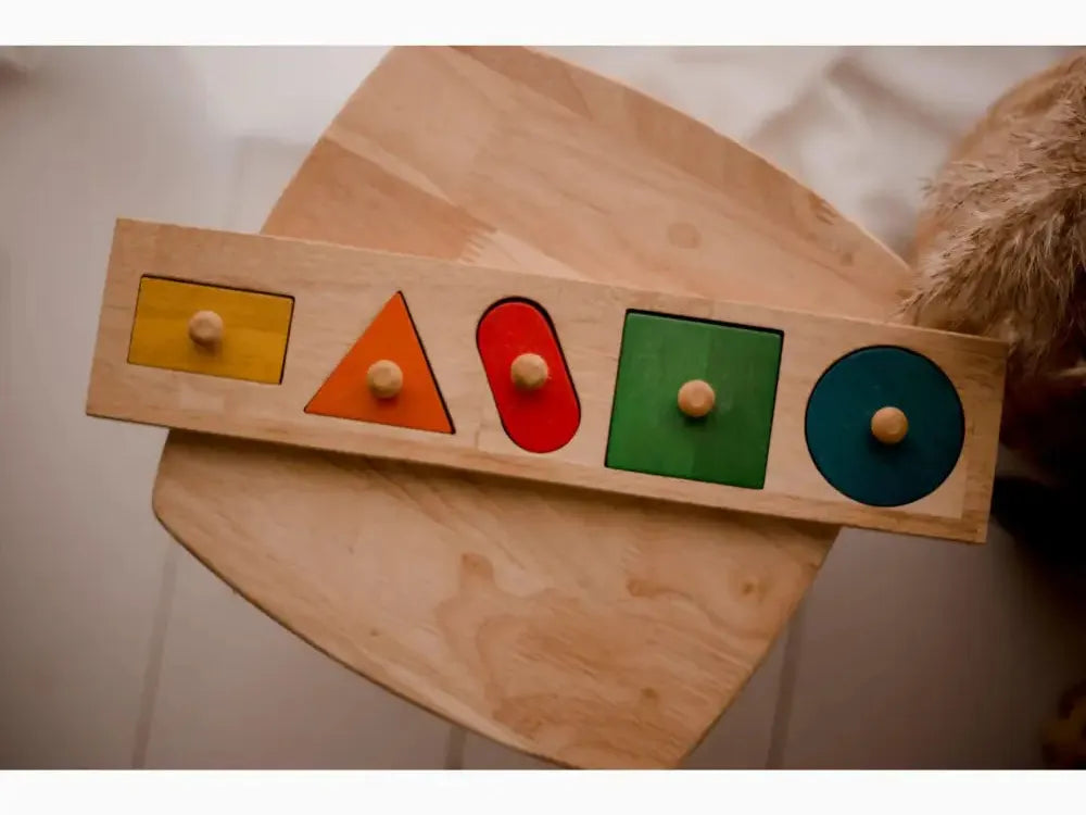 Wooden shape sorter toy with colorful geometric cutouts and matching pegs.
