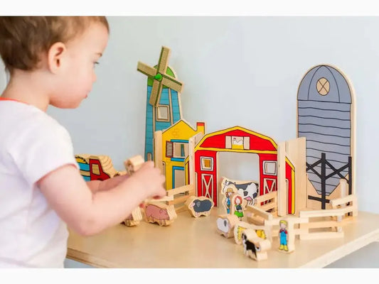 Wooden farm playset with barn, windmill, silo, and animal figures.