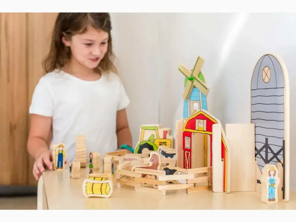 Wooden farm playset with miniature buildings, animals, and figures.