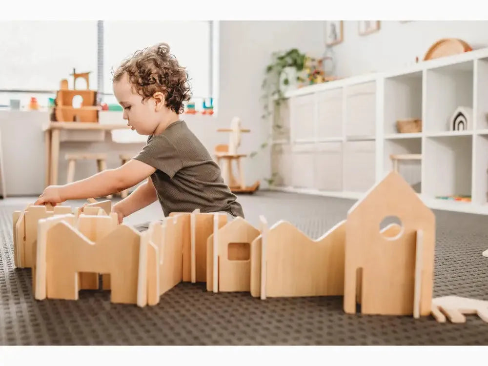 Wooden building blocks or construction toys arranged on the floor.