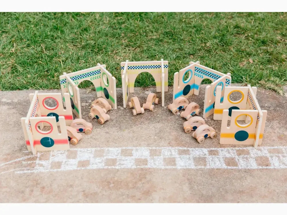 Wooden toy train set with colorful arches and blocks on a concrete surface.
