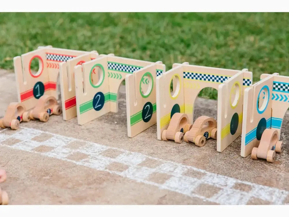 Wooden toy racing car set with numbered gates and small vehicles on a starting line.