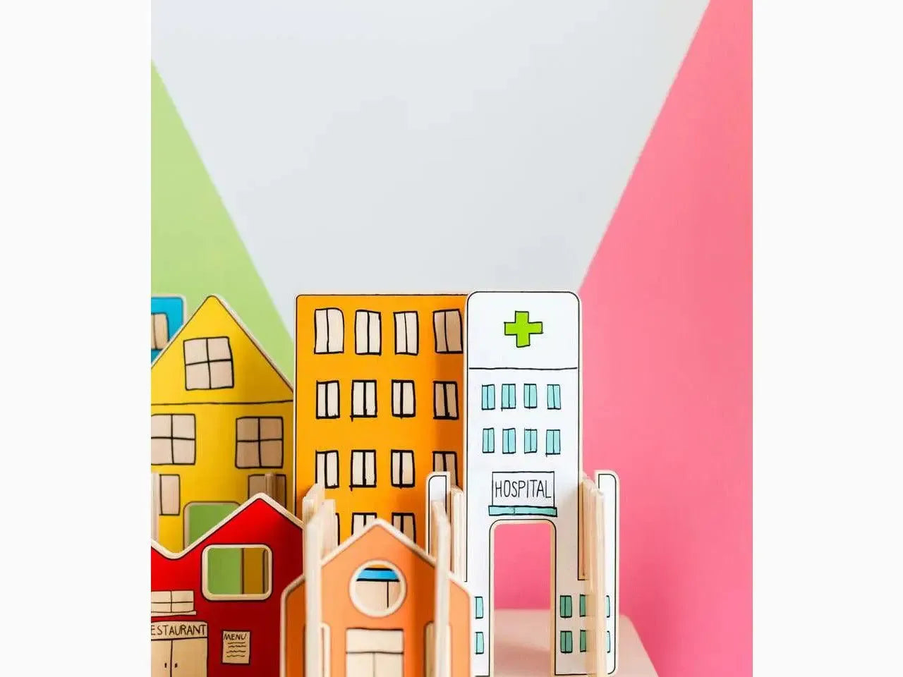 Colorful miniature wooden buildings representing a town or city, including houses and a hospital.