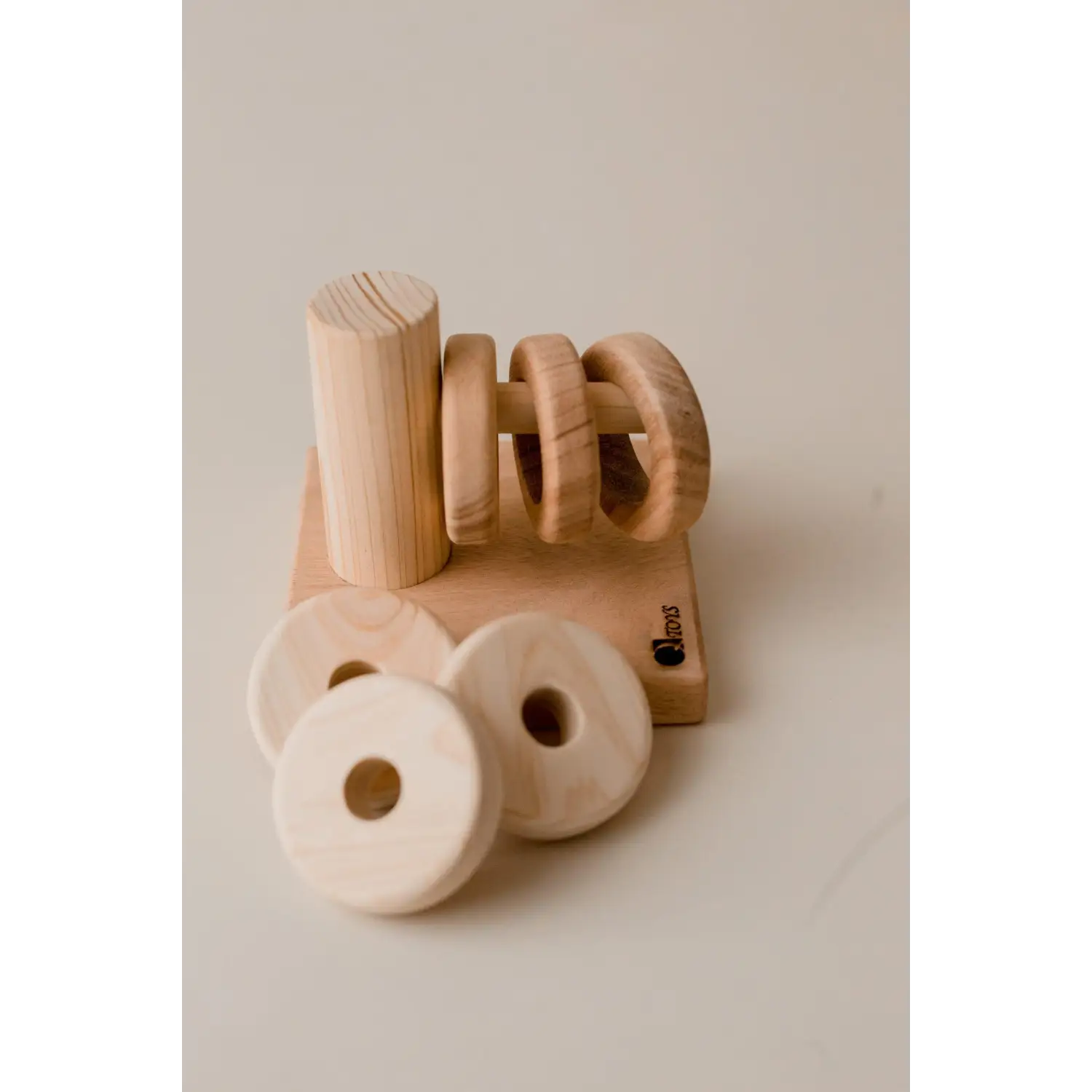 Wooden toy or puzzle piece shaped like the word ’no’ alongside circular wooden elements.