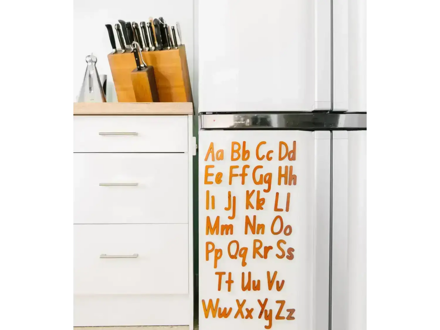 Refrigerator with colorful alphabet letters displayed on its door.
