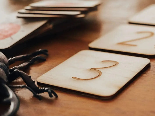 Wooden square tile with the number 3 engraved on it.