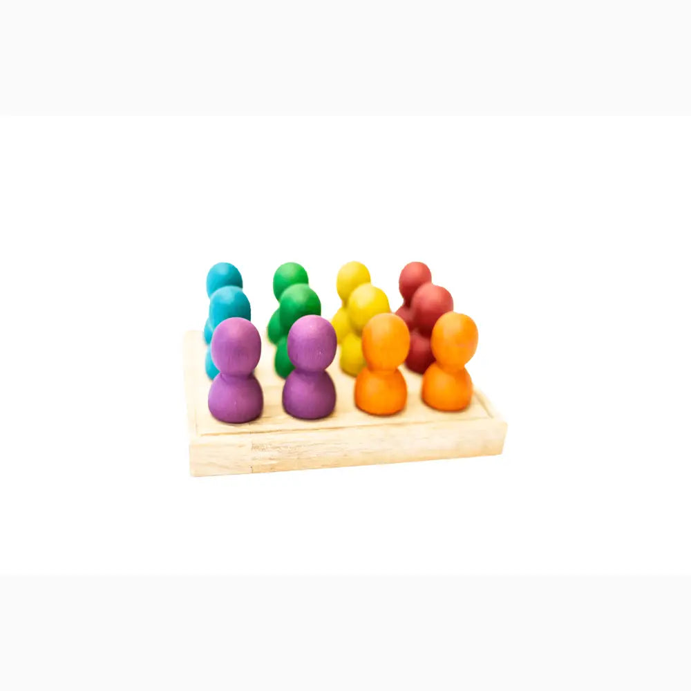 Colorful wooden peg dolls arranged in rows on a light wooden base.