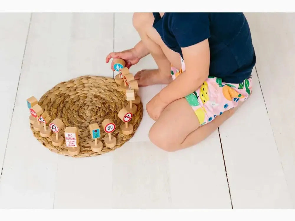 Woven straw hat decorated with small colorful toys and figurines.