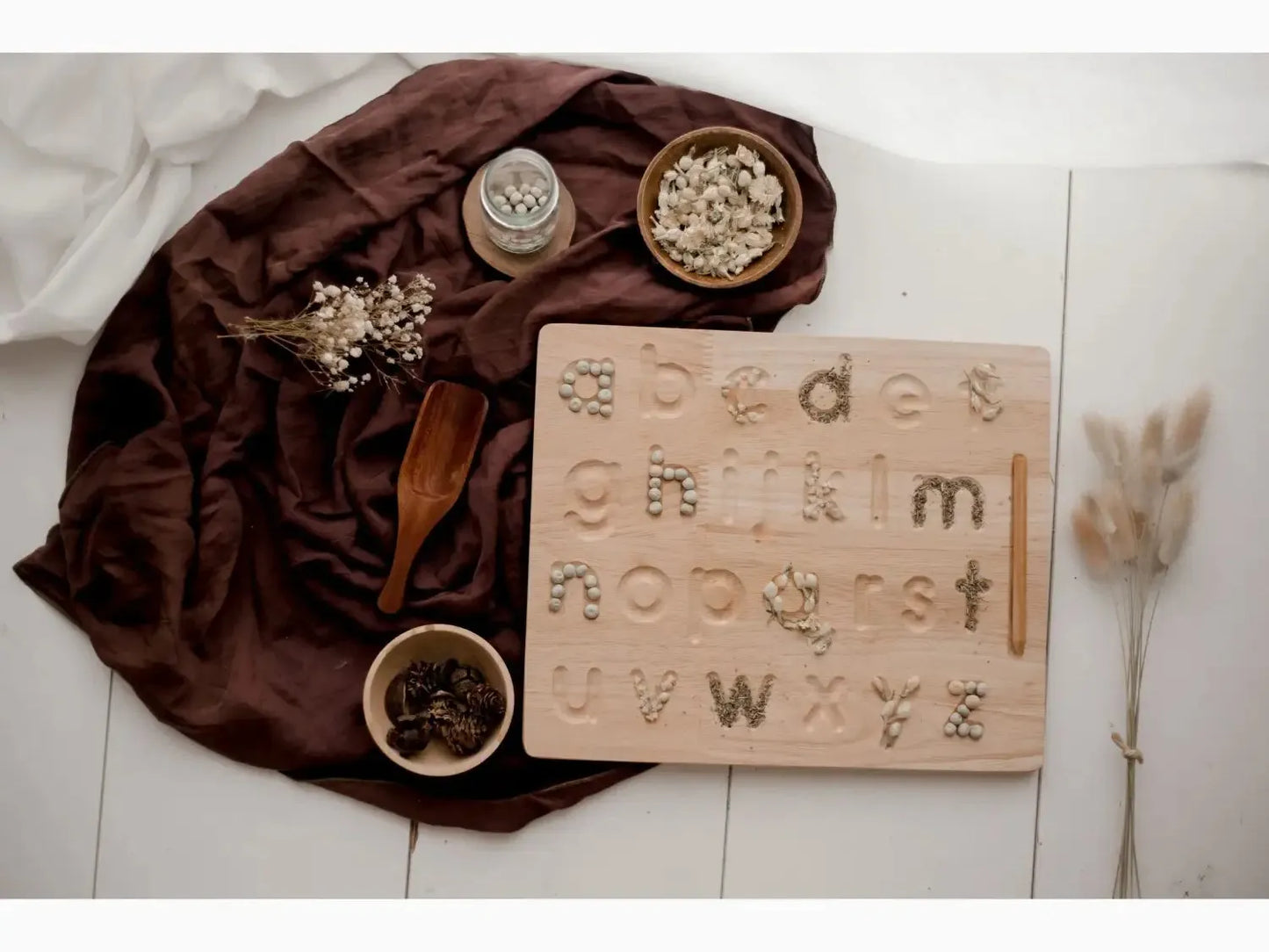 Wooden alphabet tracing board with lowercase letters and hand symbols.