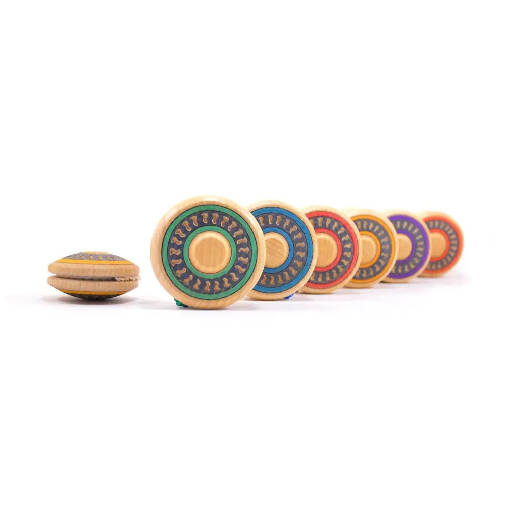 Wooden yo-yo with colorful circular discs lined up behind it.