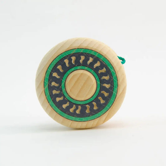Wooden yo-yo with a green and black circular design on its face.