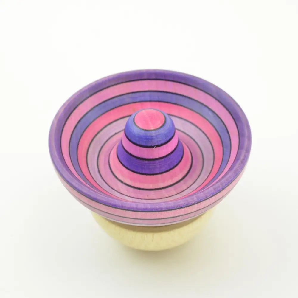 Colorful striped spinning top with concentric circles in pink and purple.
