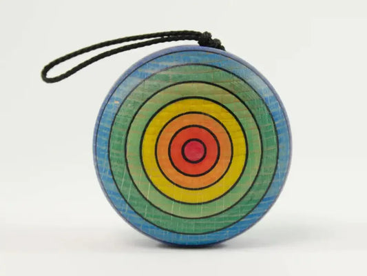 Colorful circular yo-yo with concentric rainbow rings and a black string.