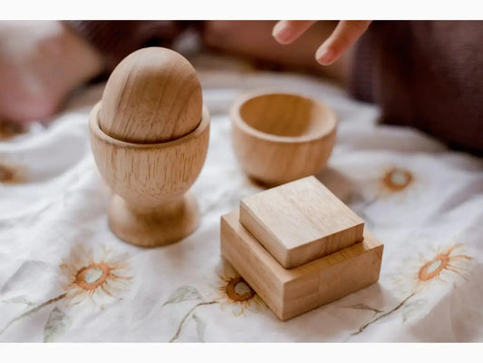 Wooden egg cup with accompanying small wooden boxes or containers.