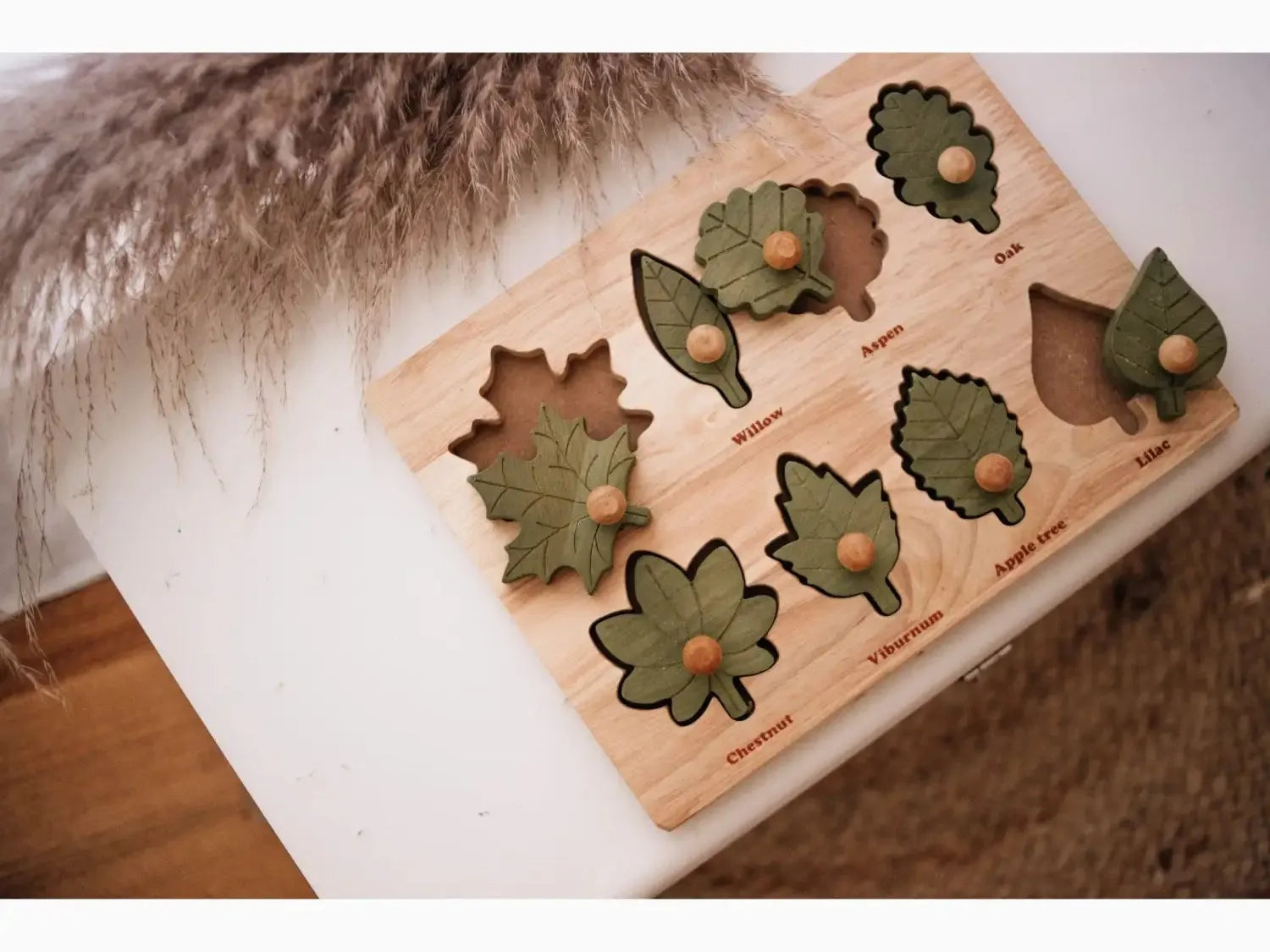 Wooden puzzle board with leaf-shaped cutouts and pieces.