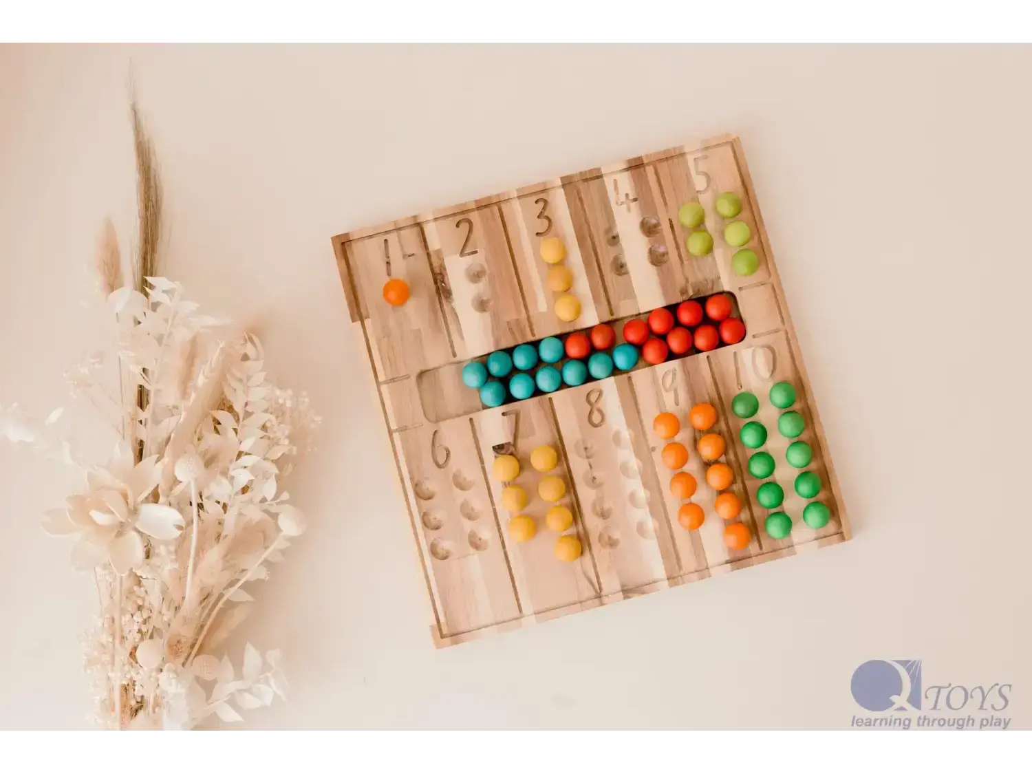 Wooden counting board with colorful beads arranged in rows next to numbers.