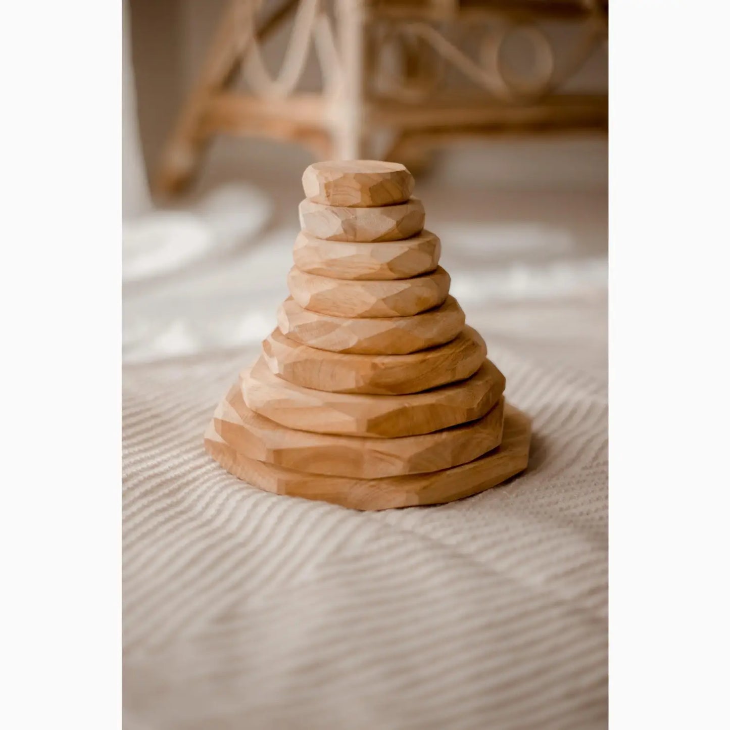 Wooden stacking toy with circular discs arranged in a pyramid shape.
