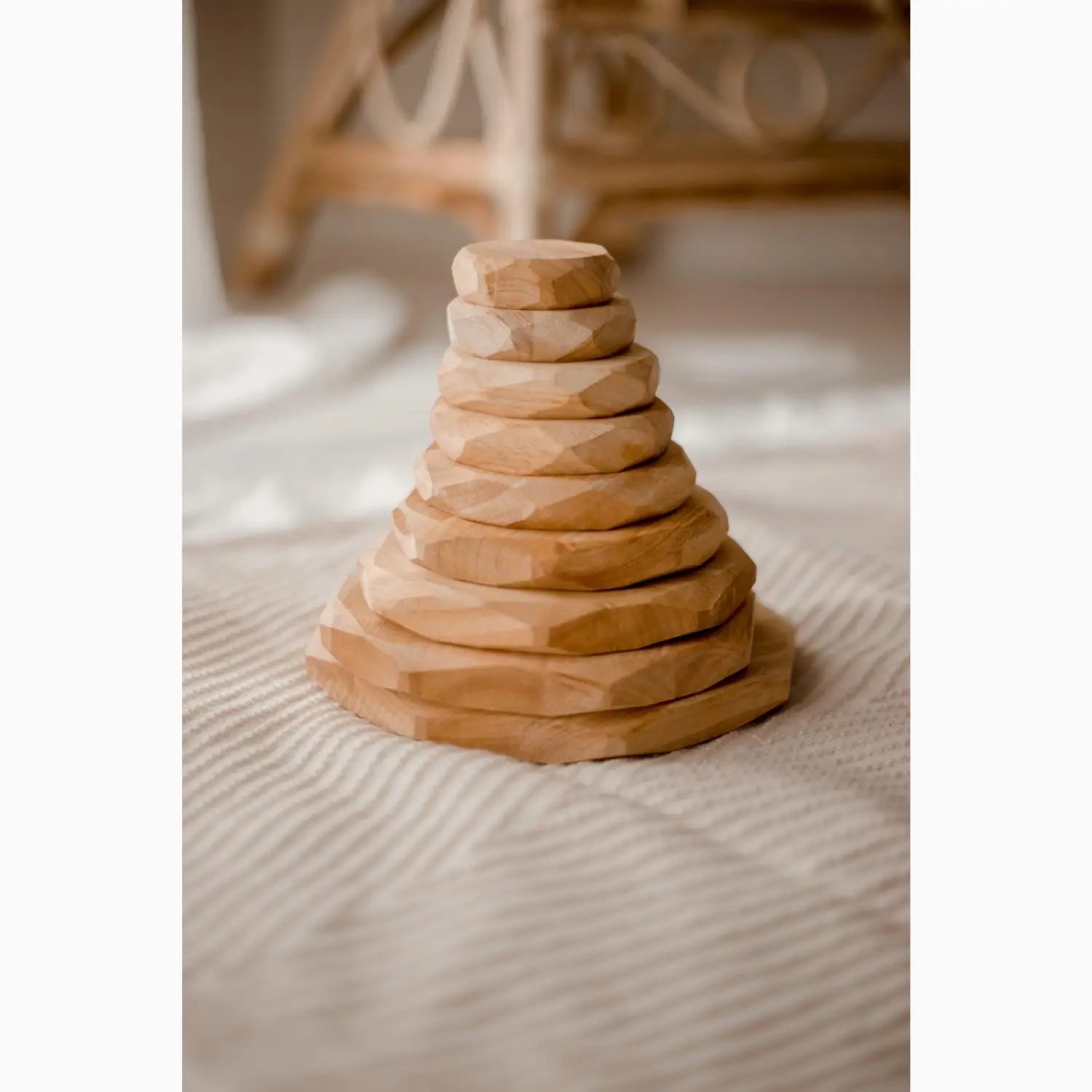 Wooden stacking toy with circular discs arranged in a pyramid shape.