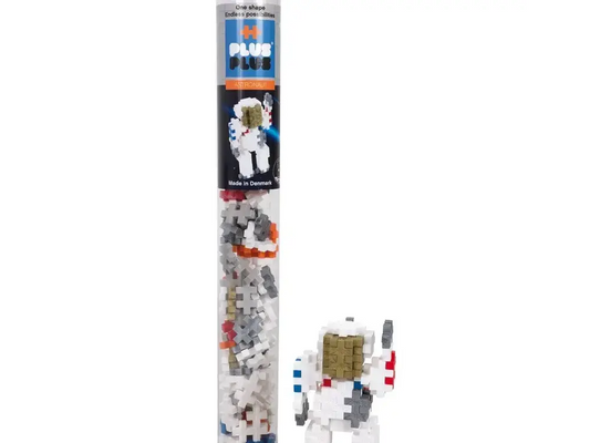 Clear plastic tube containing a space-themed building block set with an astronaut figure visible.