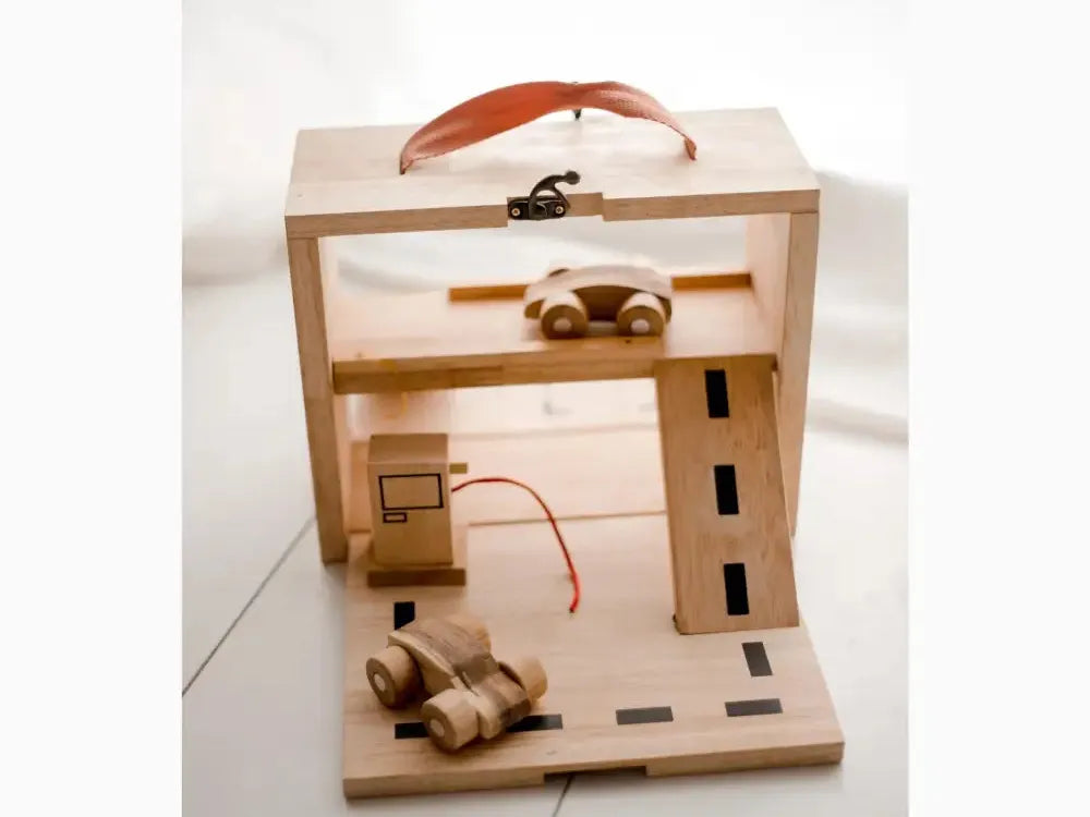 Wooden toy garage or parking structure with miniature cars and a road.