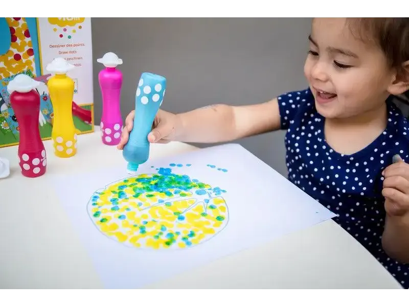 Child using colorful dot markers to create a circular pattern on paper.
