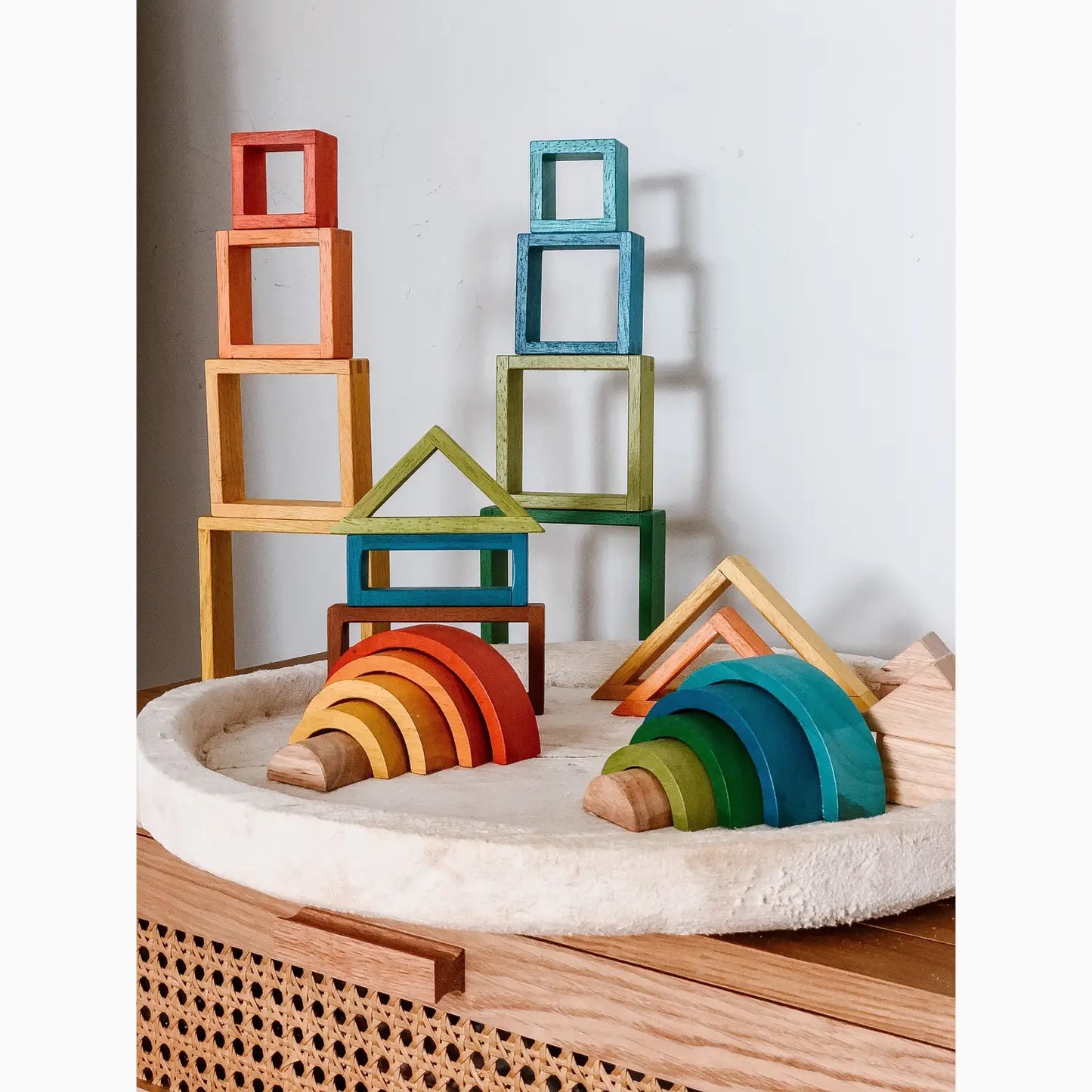 Colorful wooden building blocks and rainbow-shaped stacking toys.