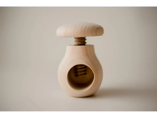 Wooden nutcracker with a round body and screw-top mechanism.