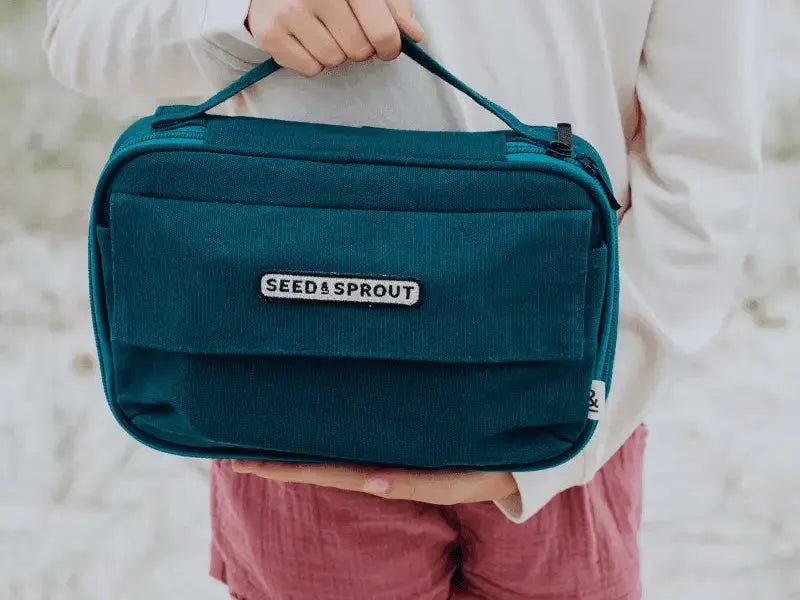 Teal-colored rectangular bag with ’Seed & Sprout’ branding and multiple compartments.