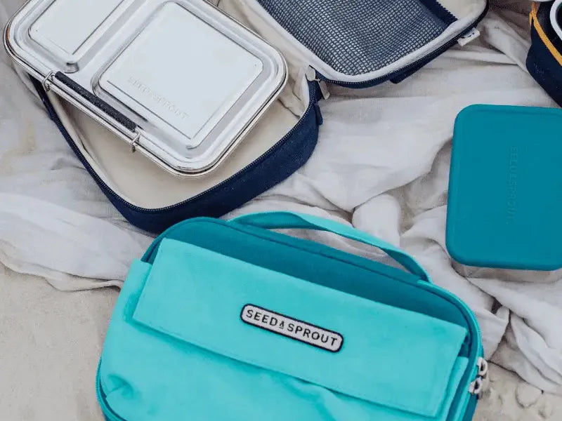 Teal-colored insulated lunch bag with ’Stasher’ branding.