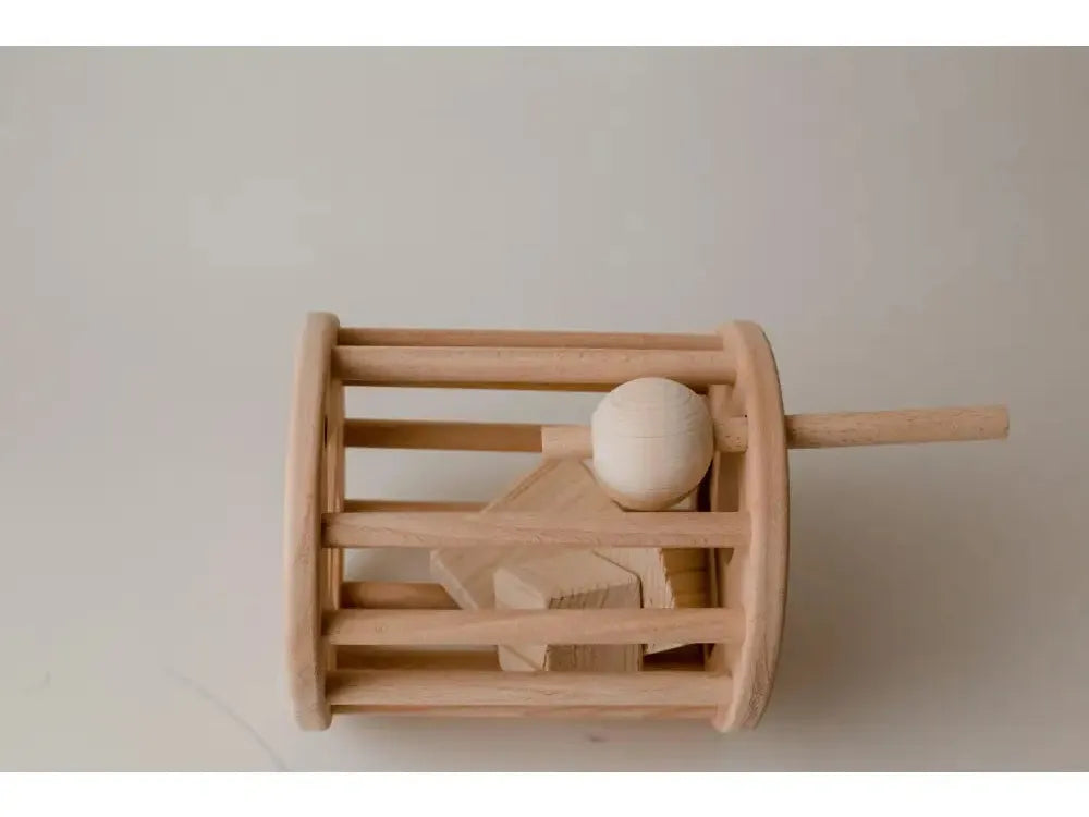 Wooden toy drum with a stick and ball inside.