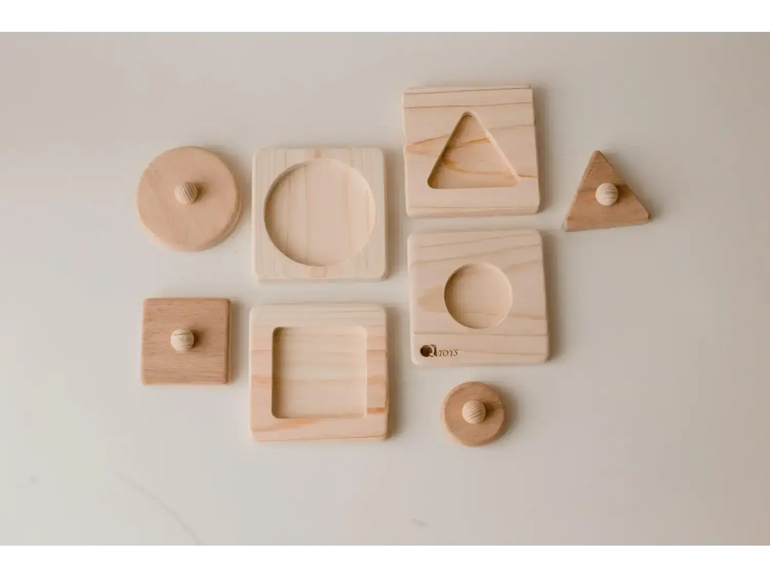 Collection of wooden geometric shapes and blocks with various cutouts and indentations.