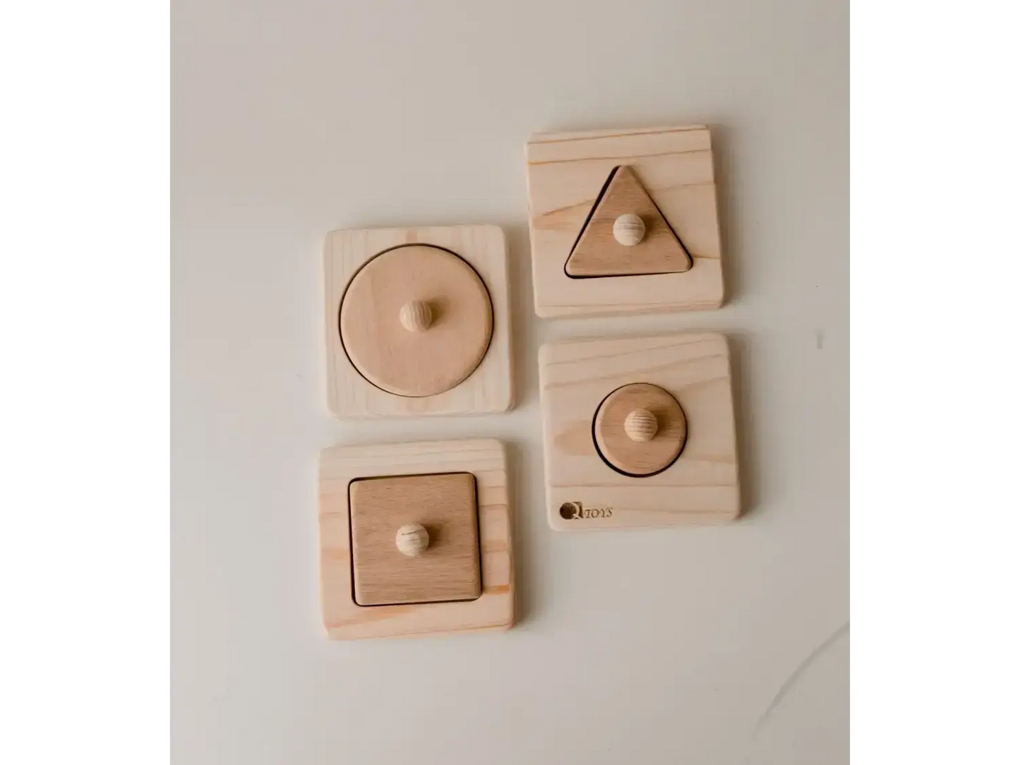 Set of wooden shape puzzles with circular, triangular, and square pieces.
