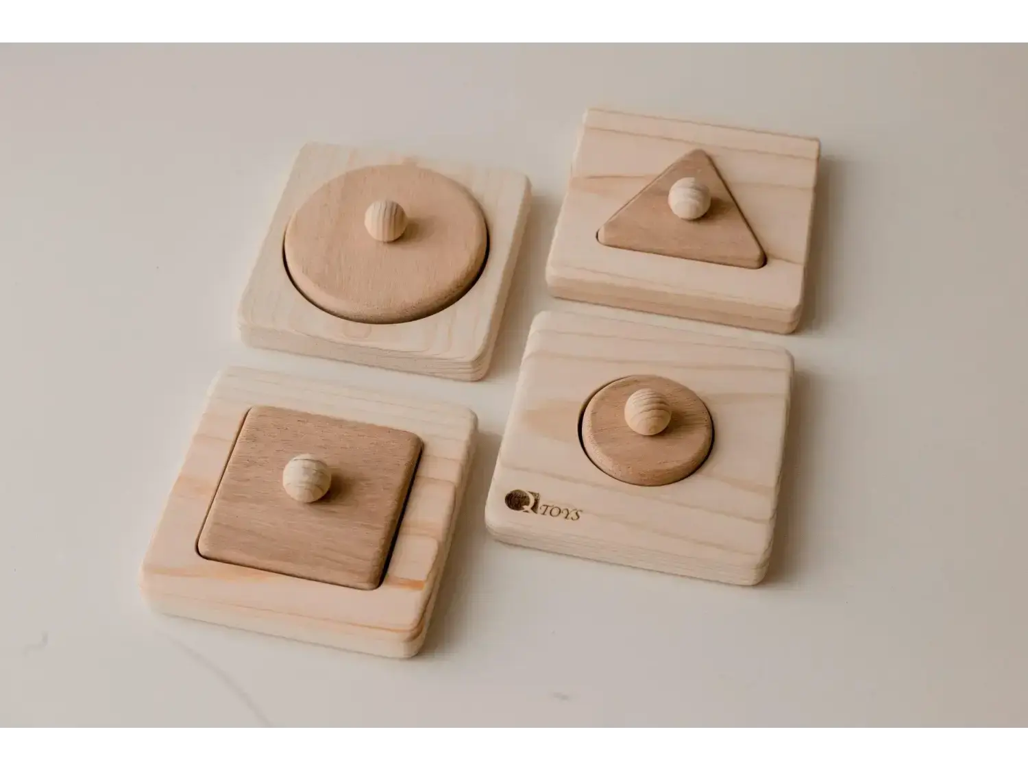 Set of wooden shape puzzles for children featuring circles, squares, and triangles.