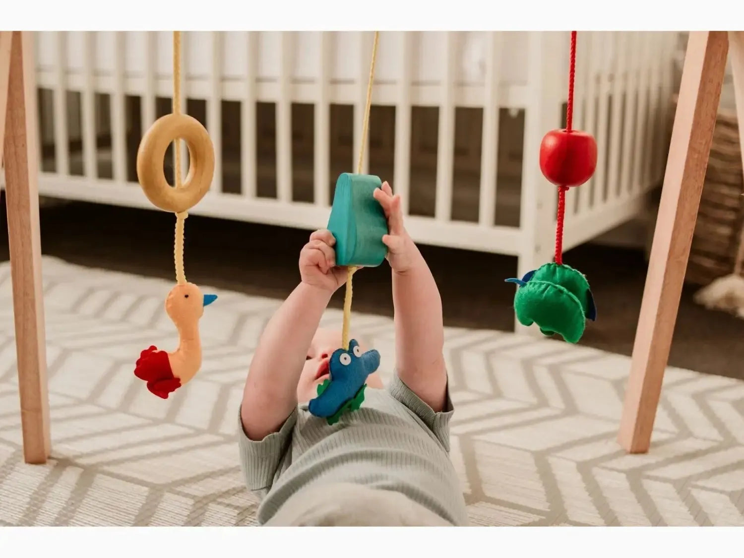 Baby playing with a wooden gym toy.