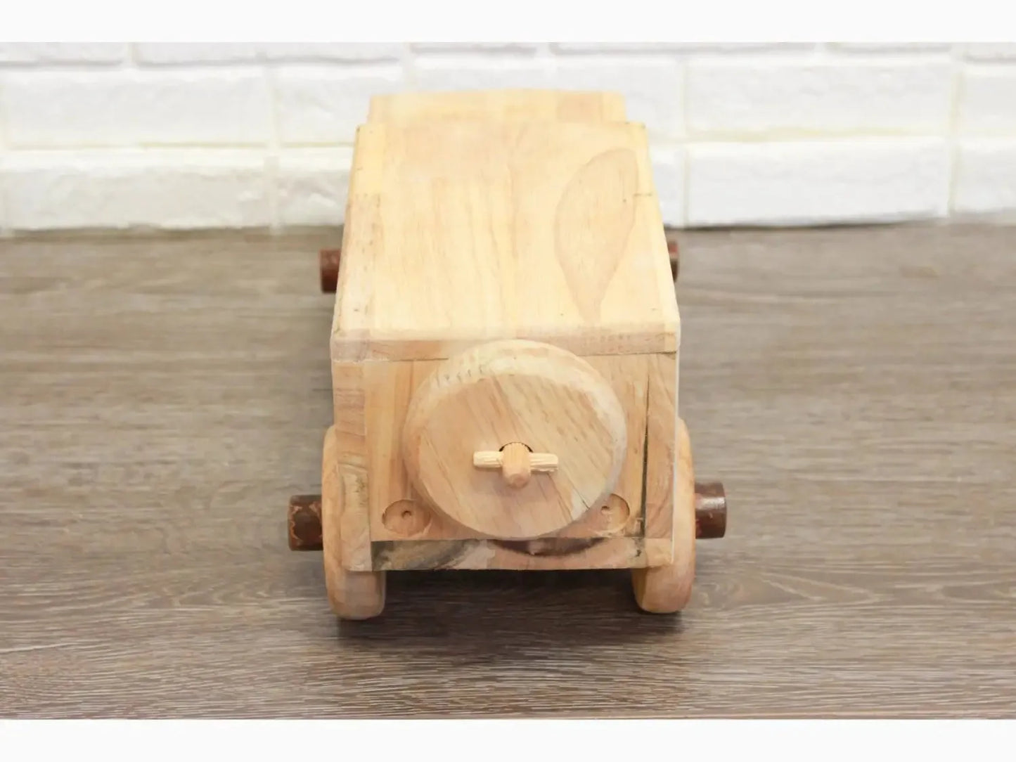 Wooden toy truck with a circular detail on its rear.
