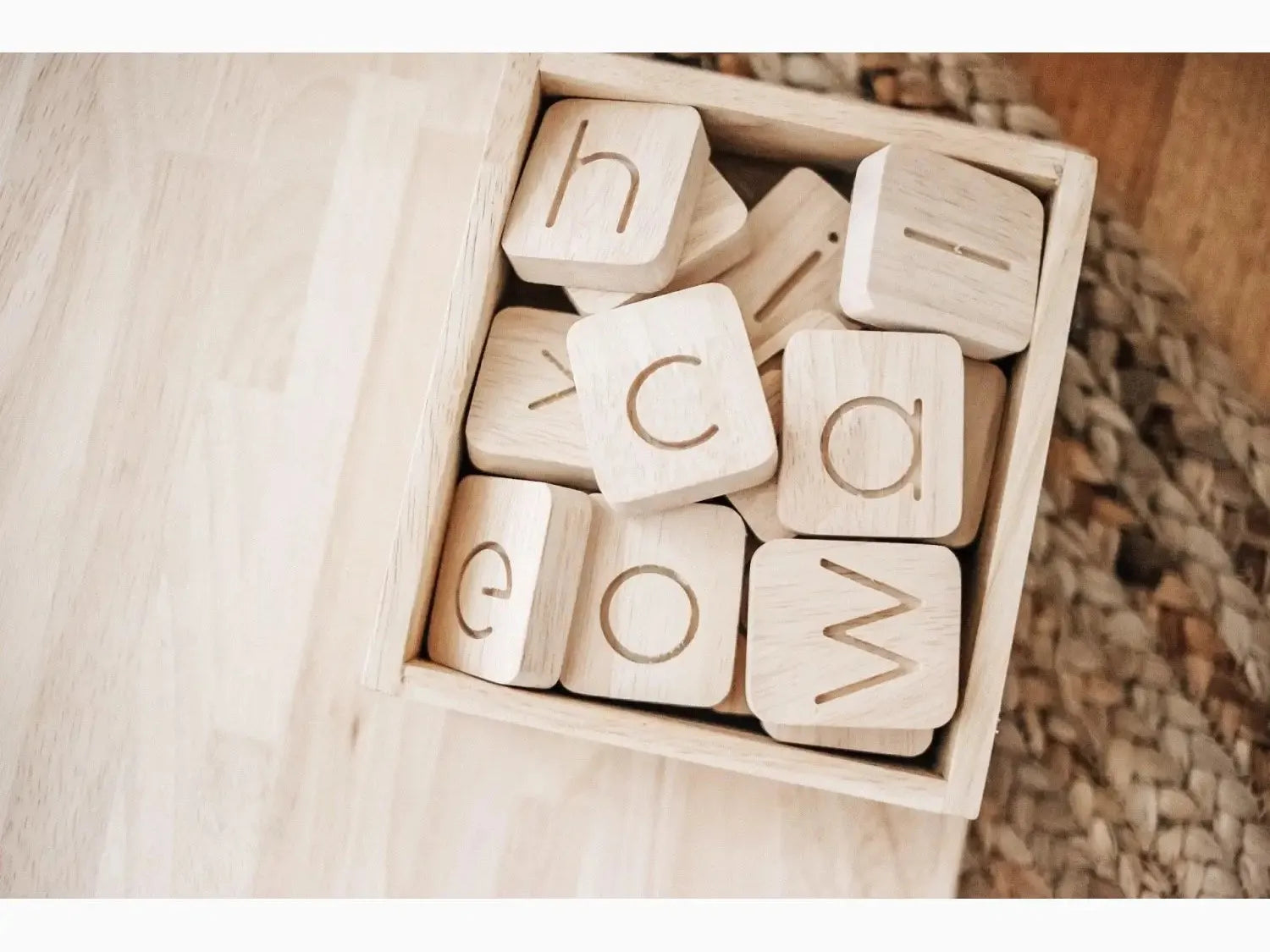 Wooden blocks with engraved letters in a box.