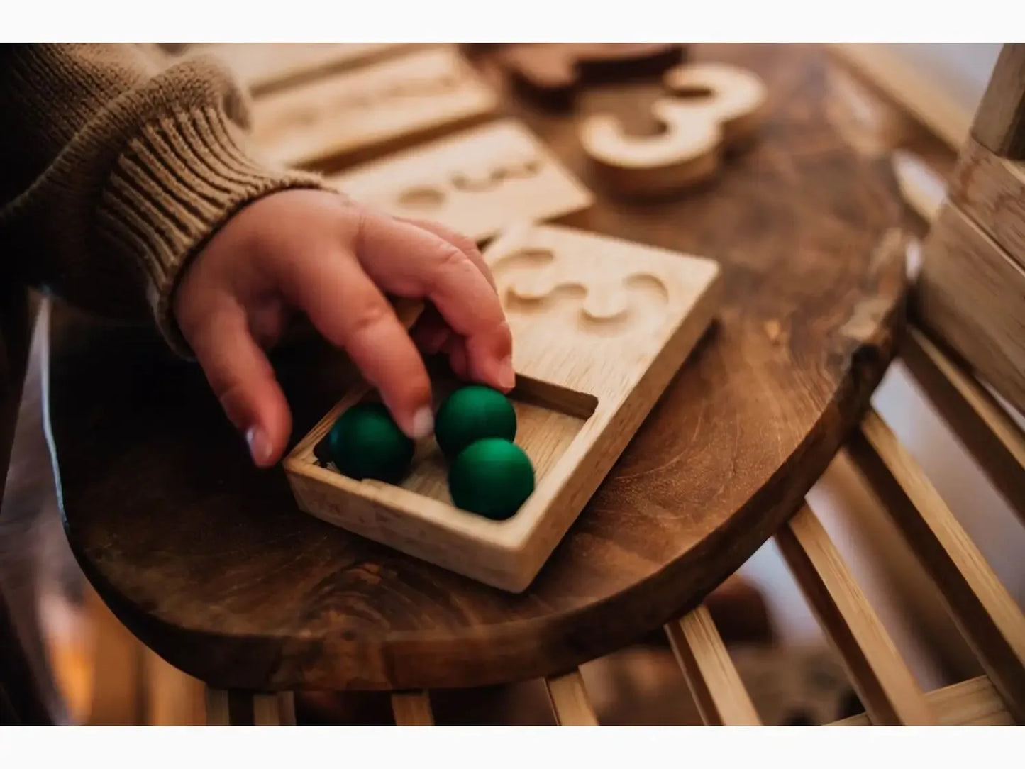Wooden number puzzle with green balls.