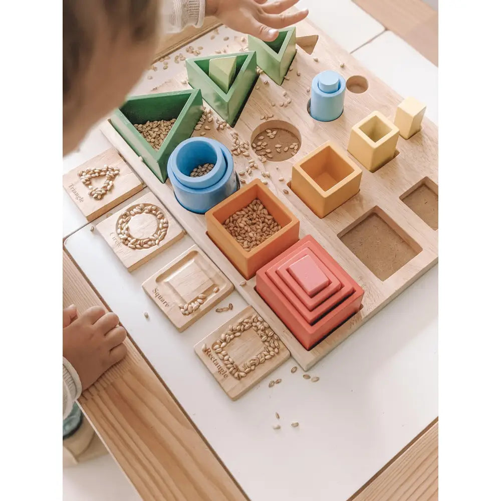 Montessori-style educational toy set with various geometric shapes and containers.