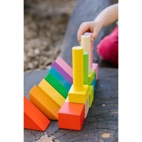Colorful wooden toy blocks stacked in various shapes and sizes.