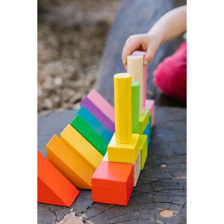 Colorful wooden toy blocks stacked in various shapes and sizes.