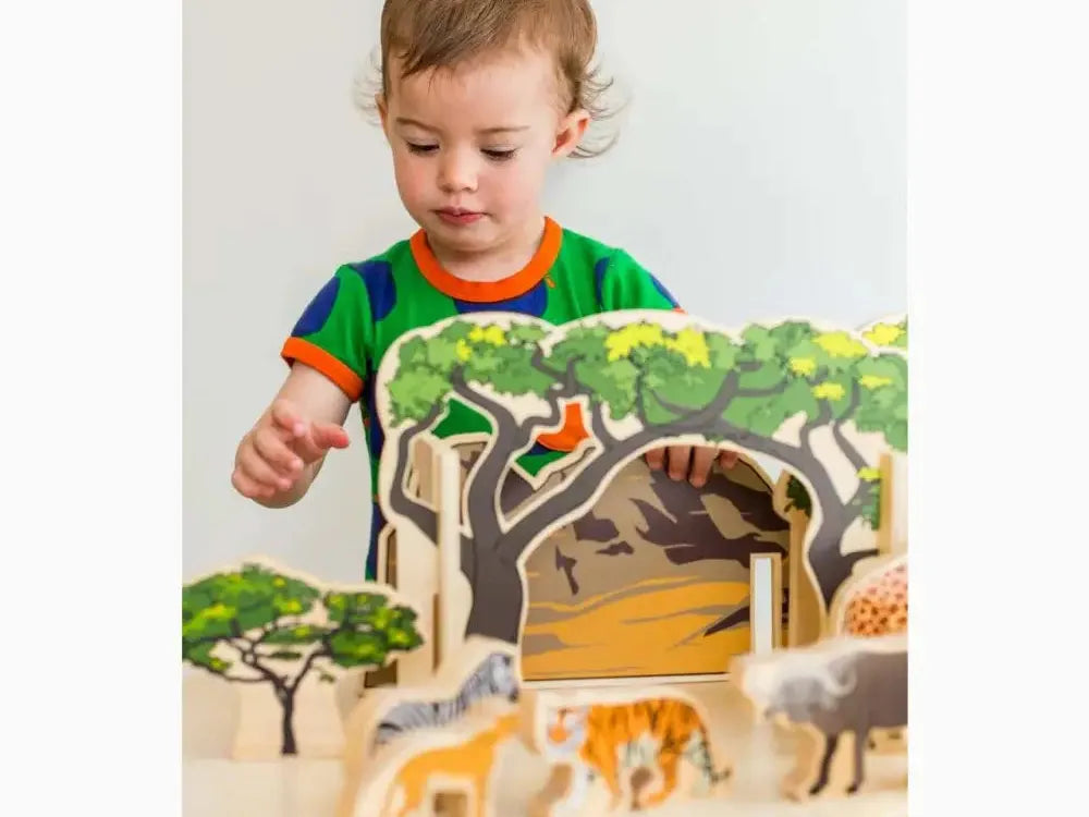Wooden toy safari playset with trees and animal figurines.