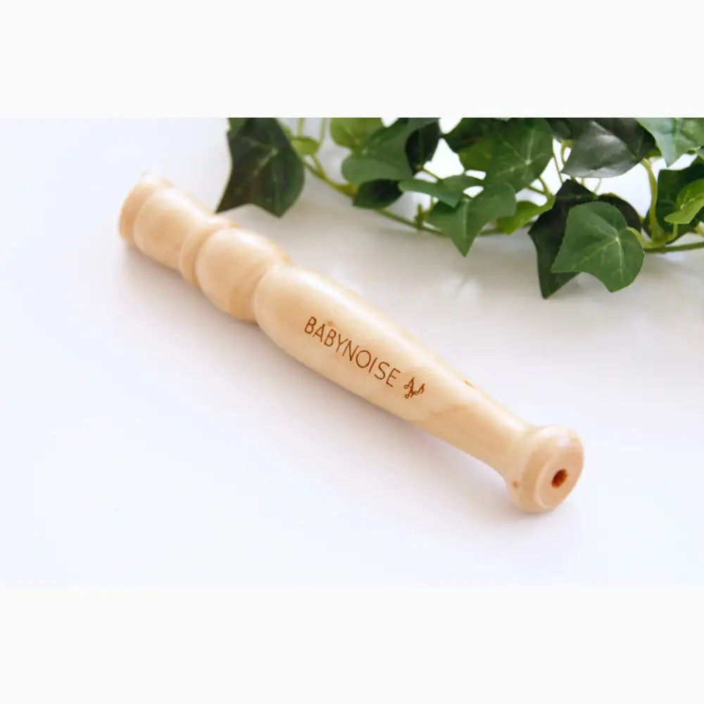 Wooden flute or whistle with ’BABYNOISE’ engraved on it.