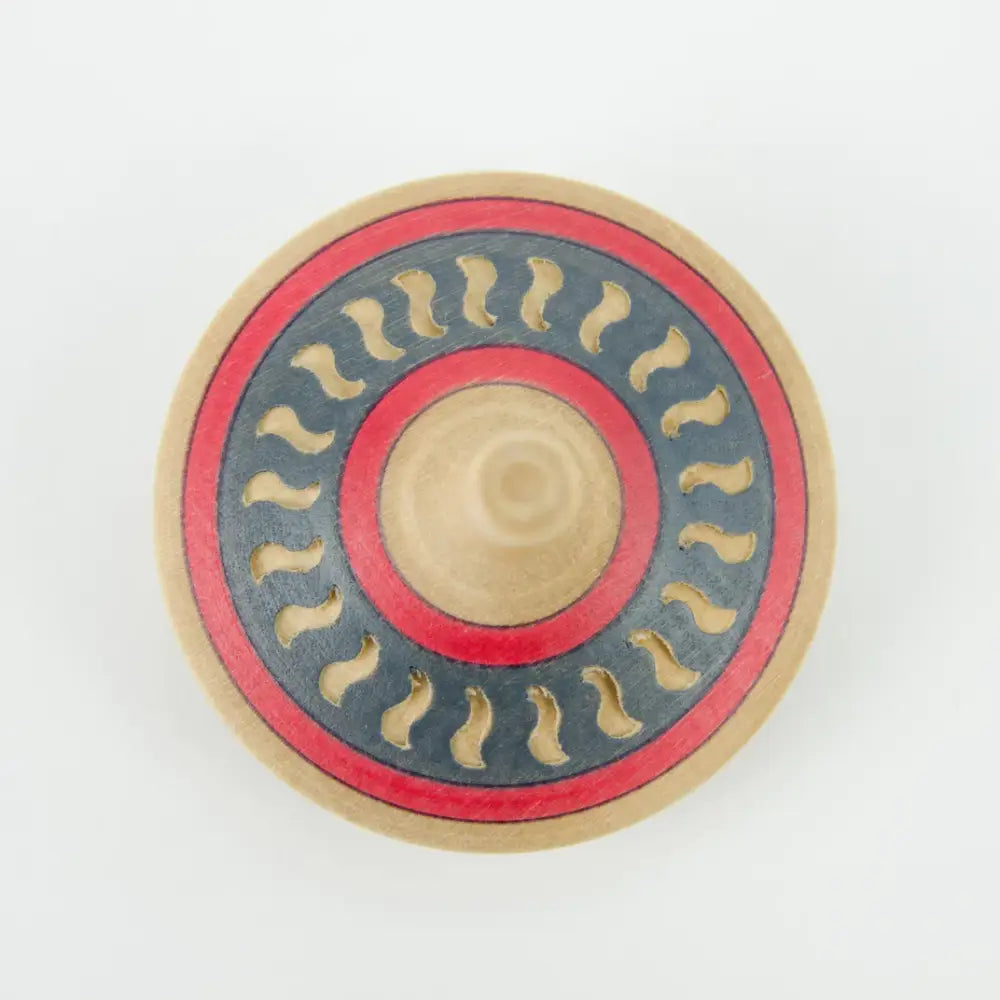 Circular decorative shield or medallion with concentric rings and wavy patterns.