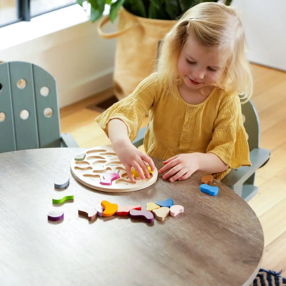 Young child playing with a wooden shape-sorting puzzle toy.