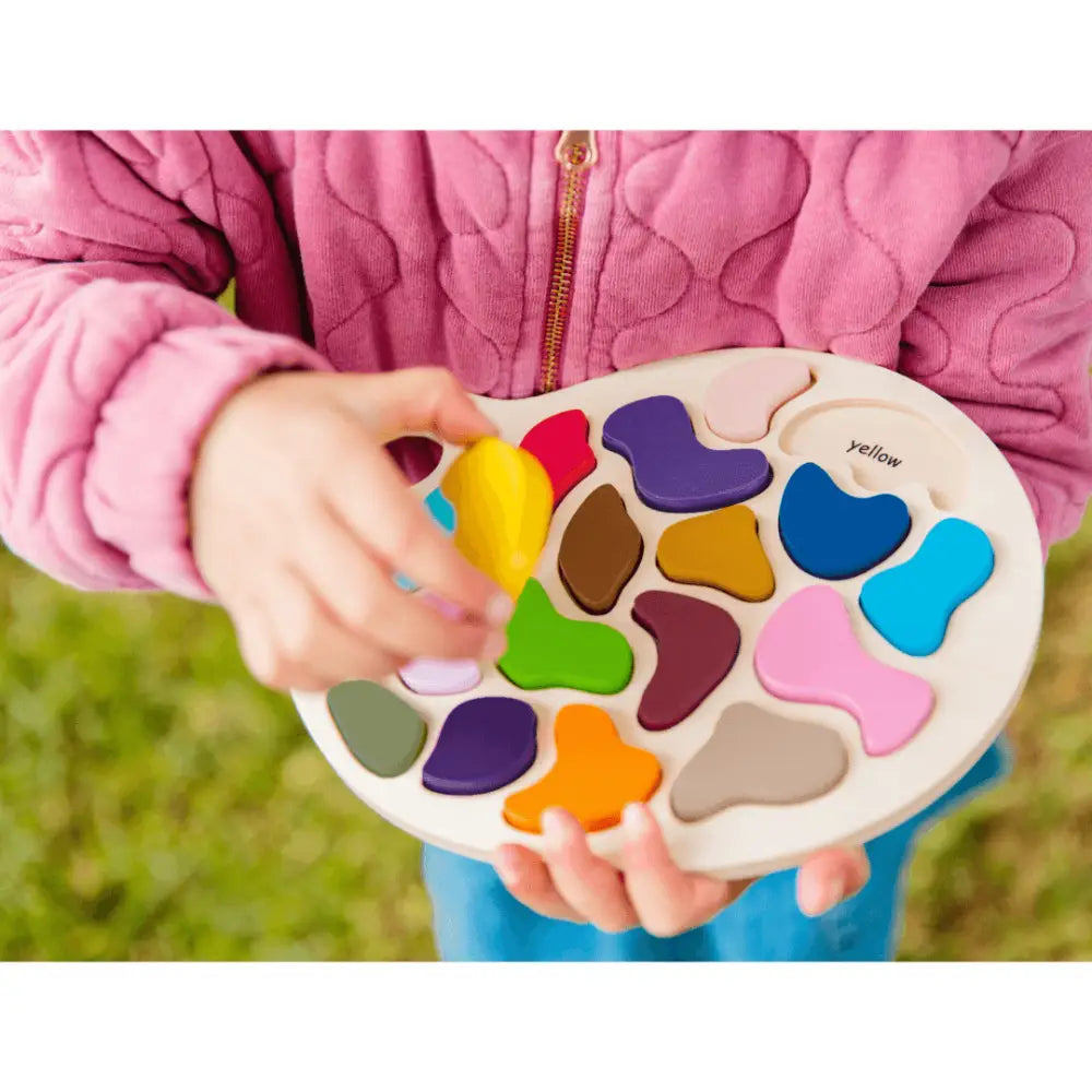 Colorful wooden shape-sorting puzzle toy held by small hands.