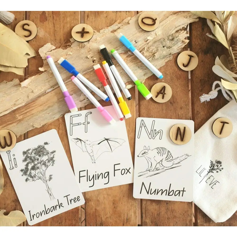 Educational materials for teaching alphabet and animal vocabulary, including flashcards, colored markers, and wooden letter pieces.