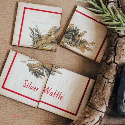 Broken wooden plaque with dried flowers and ’Silver Wattle’ text.
