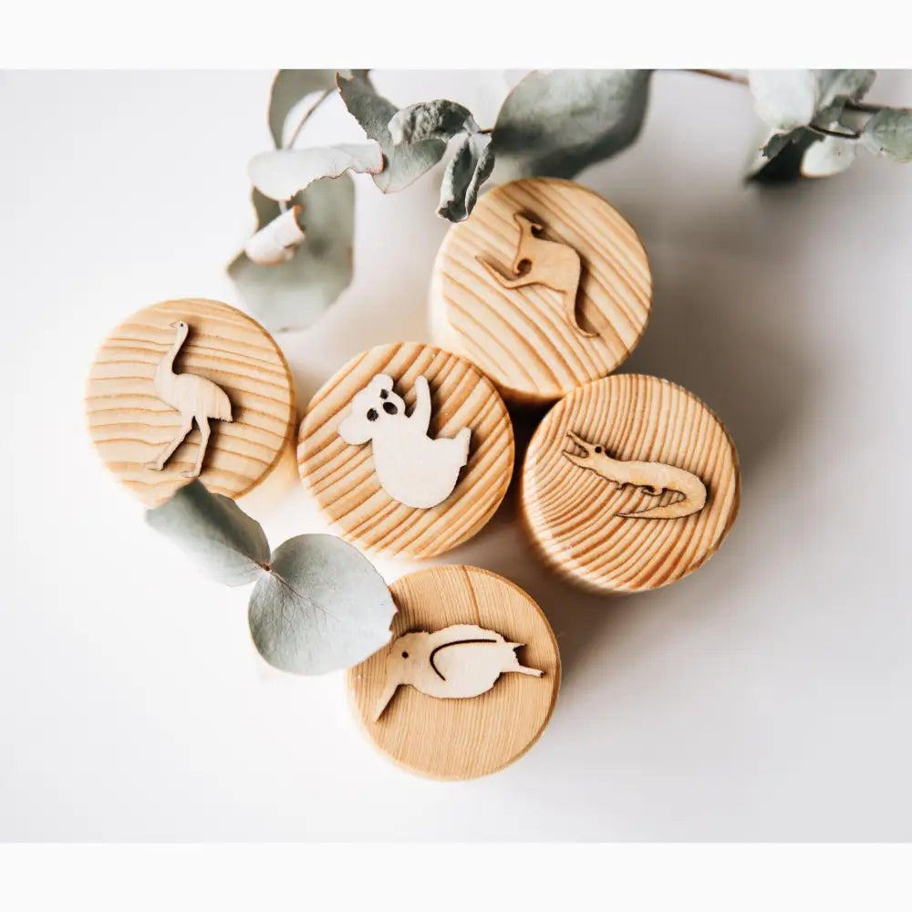 Wooden circular stamps or tokens with animal silhouettes carved into them.