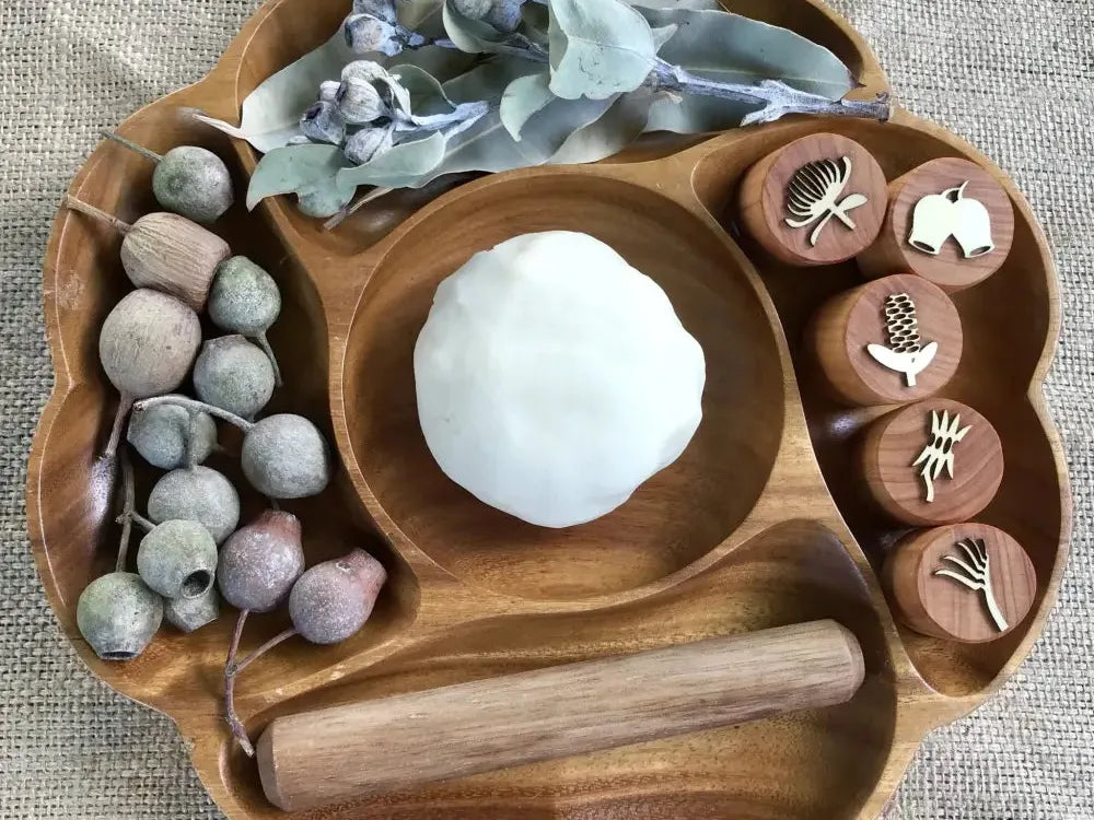 Wooden tray with compartments containing various natural and decorative elements.